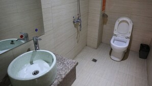 A bathroom with a sink, toilet, and shower. - Biancheng International Youth Hostel (Xiangxi)