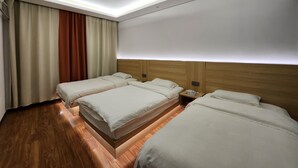 A hotel room with three beds, wooden headboards, a large window with curtains, and a ceiling light. - Biancheng International Youth Hostel (Xiangxi)