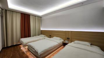 Habitación triple clásica, vista a la ciudad | Escritorio, espacio para trabajar con laptop y cortinas blackout