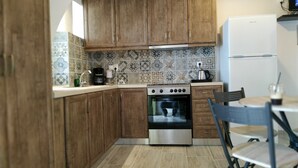 Une cuisine avec des meubles en bois, un four en acier inoxydable et un réfrigérateur blanc.