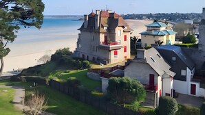 A coastal property with a large house, a beach view, and a fenced garden. - Apartment 'Newport Vue Mer' with Sea View, Private Terrace and Wi-Fi (Saint-Cast-le-Guildo)