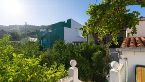 Un quartier résidentiel caractérisé par une clôture blanche, une végétation luxuriante et des bâtiments à l’architecture moderne.