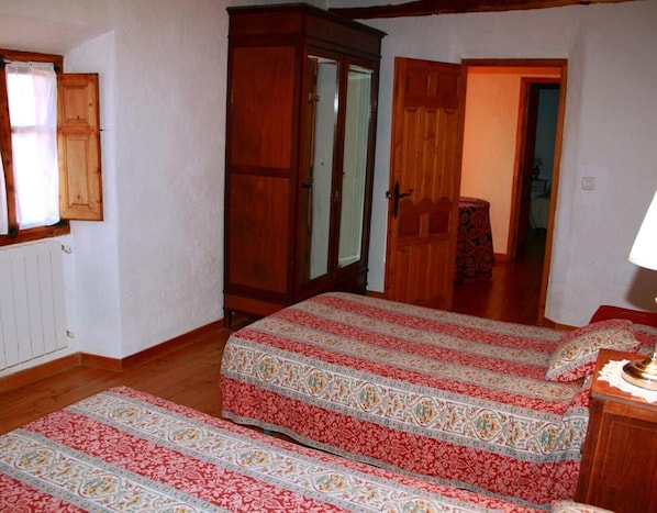 A room with a bed, a wardrobe, and a mirror.