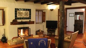 A cozy living room with a fireplace, a television, and comfortable seating.