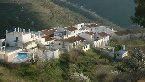 A coastal village with white buildings, a swimming pool, and a view of the sea. - Country House 'The Tack Room' with Mountain View, Shared Pool and Wi-Fi (Rubite)