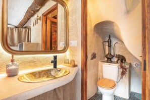 A bathroom with a wooden vanity, a gold sink, a toilet, and a mirror with a wooden frame. - Apartment 'Duende' with Mountain View, Balcony and Air Conditioning (Olba)