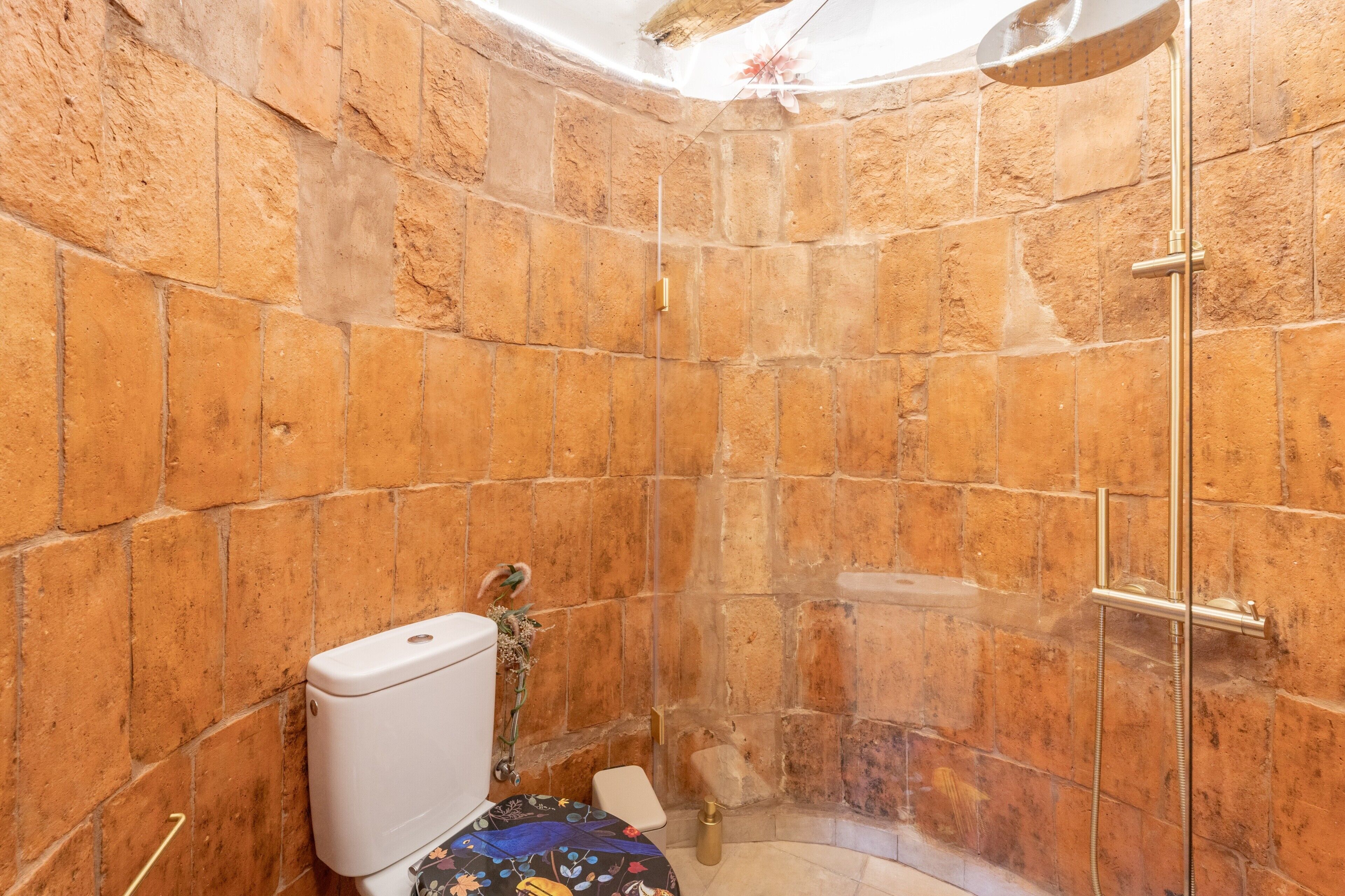 Ein Badezimmer mit Toilette, Dusche und Fliesen.