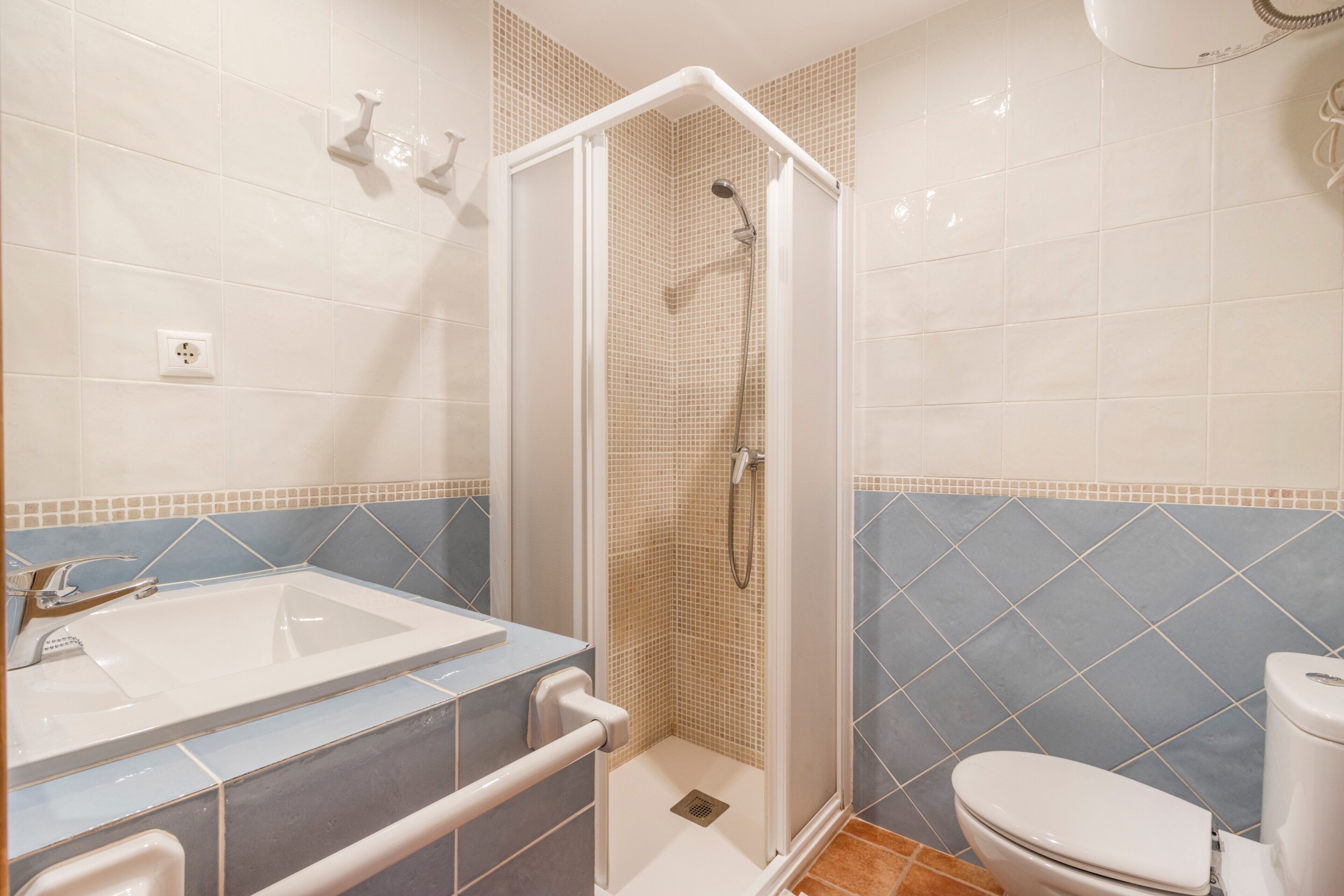A bathroom with a shower, toilet, and sink.