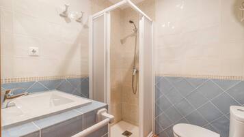 A bathroom with a shower, toilet, and sink.