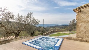 A hot tub on a patio with a view of the countryside. - Apartment 'Las Planeras' with Mountain Views, Shared Pool and Wi-Fi (Graus)