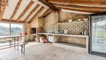 Una cocina rústica con vigas de madera a la vista, salpicadero de azulejos y un amplio ventanal con vistas panorámicas.