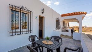A patio with a table and chairs, a potted plant, and a view of the landscape. - Apartment 'Citronela' with Private Terrace and Air Conditioning (Nijar)