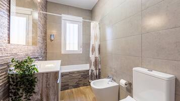 A bathroom with a bathtub, toilet, and sink.