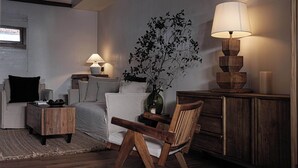 A cozy room with a sofa, a wooden chair, a small table with a vase, and two lamps. - Li Jiang Ancient City Wide-Up Hotel (Lijiang)
