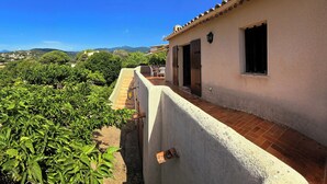 A building with a balcony overlooking a vineyard and a clear blue sky. - Villa that sleeps 6, with a terrace and views of the sea and the Gulf of Ajaccio. Beach 200 m away (Pietrosella)
