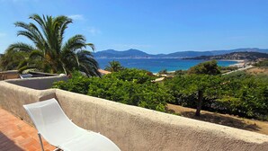 A balcony with a white chair overlooking a coastal landscape with mountains and a clear sky. - Villa that sleeps 6, with a terrace and views of the sea and the Gulf of Ajaccio. Beach 200 m away (Pietrosella)