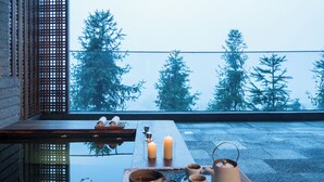 Un ambiente interior tranquilo con vistas a altos árboles a través de una ventana.