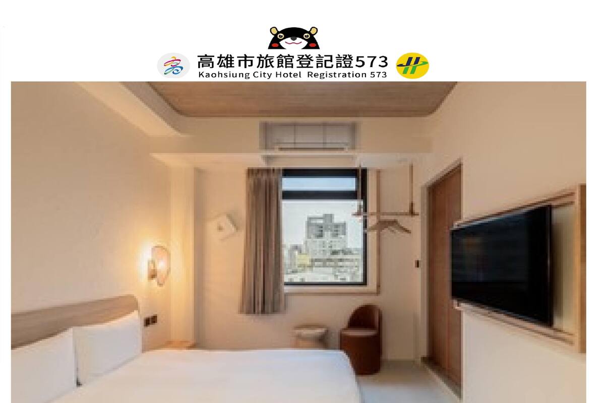 A hotel room with a bed, a television, a window, and a view of the city.