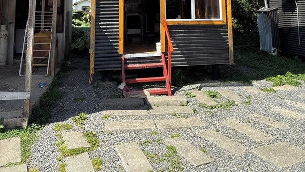 A two-story building with a small porch and a window. - Mateo Puyuhuapi Cabin (Puyuhuapi)