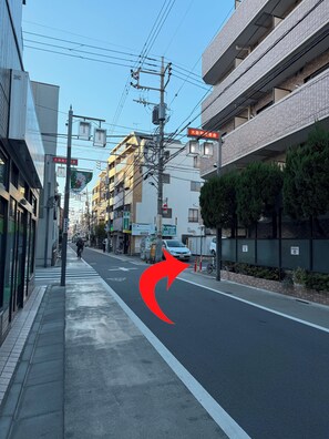 Eine Straße mit Gebäuden, ein klarer Himmel und ein roter Pfeil, der nach rechts zeigt.