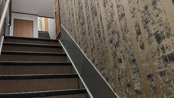 A staircase with a textured wall and a handrail.
