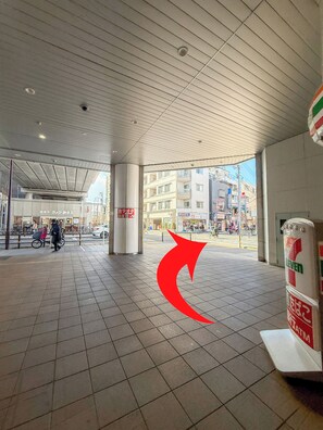 Ein großzügiger Innenbereich mit Fliesenboden, hoher Decke und Blick auf die Straße.