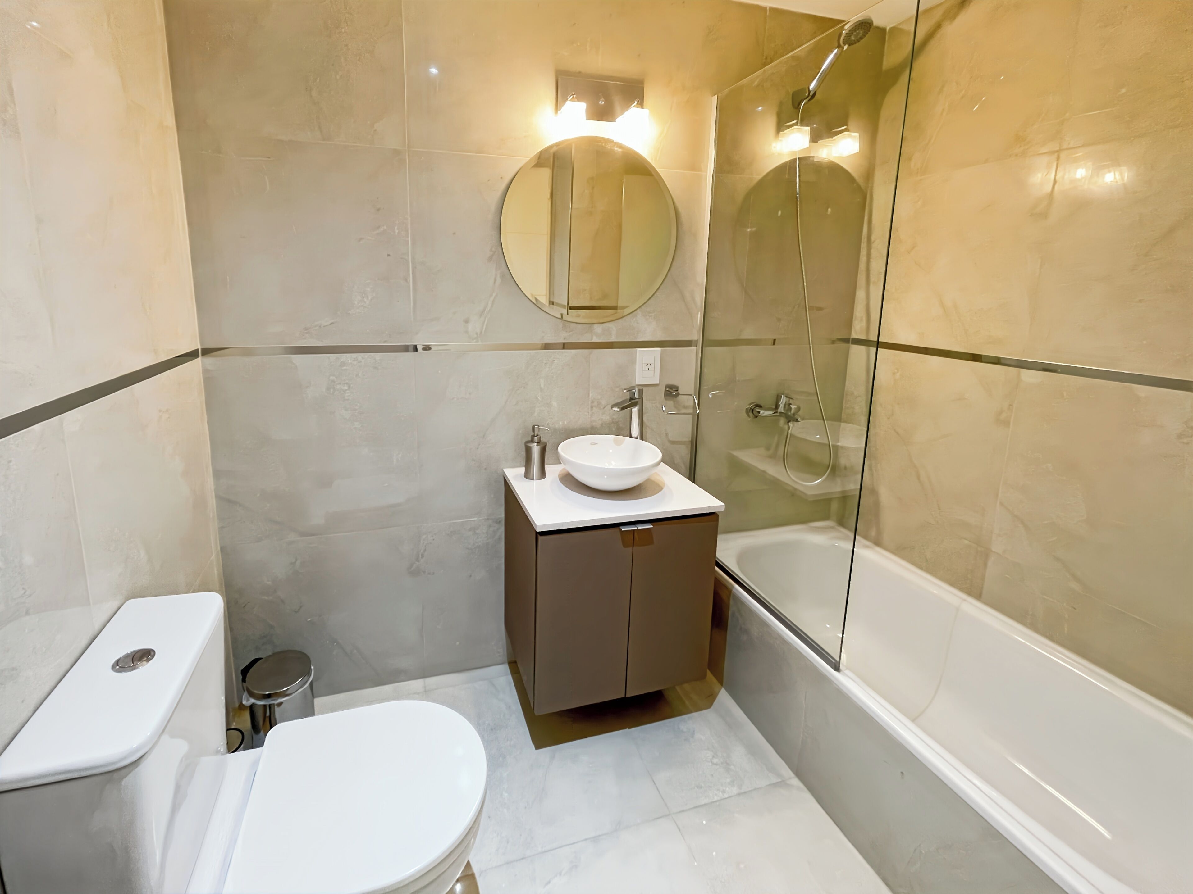 Ein modernes Badezimmer mit Toilette, Waschbecken und einer Duschkabine.