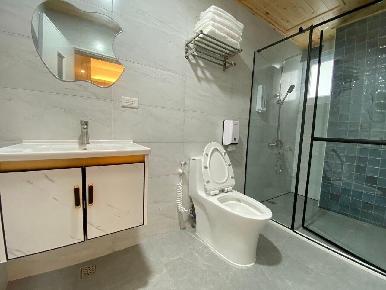 A modern bathroom with a toilet, sink, and shower.