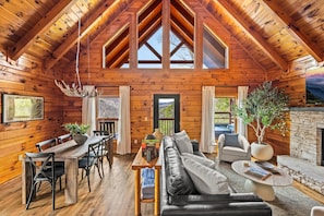 View of the living room with dining table nearby. - Hot Tub | Fire Pit | Mountain Views | Game Loft | Prime Smoky Mountain Location (Pigeon Forge)