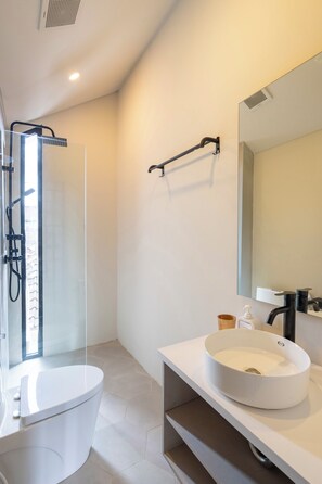 A modern bathroom with a toilet, sink, and shower. - Jane Berawa Villa by Betterplace (Canggu)