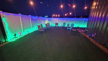 An outdoor patio area with chairs and string lights.