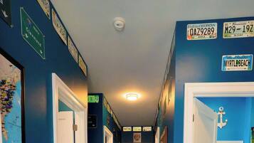 Un pasillo con señalización direccional, una señal de parada y un mapa enmarcado en la pared.