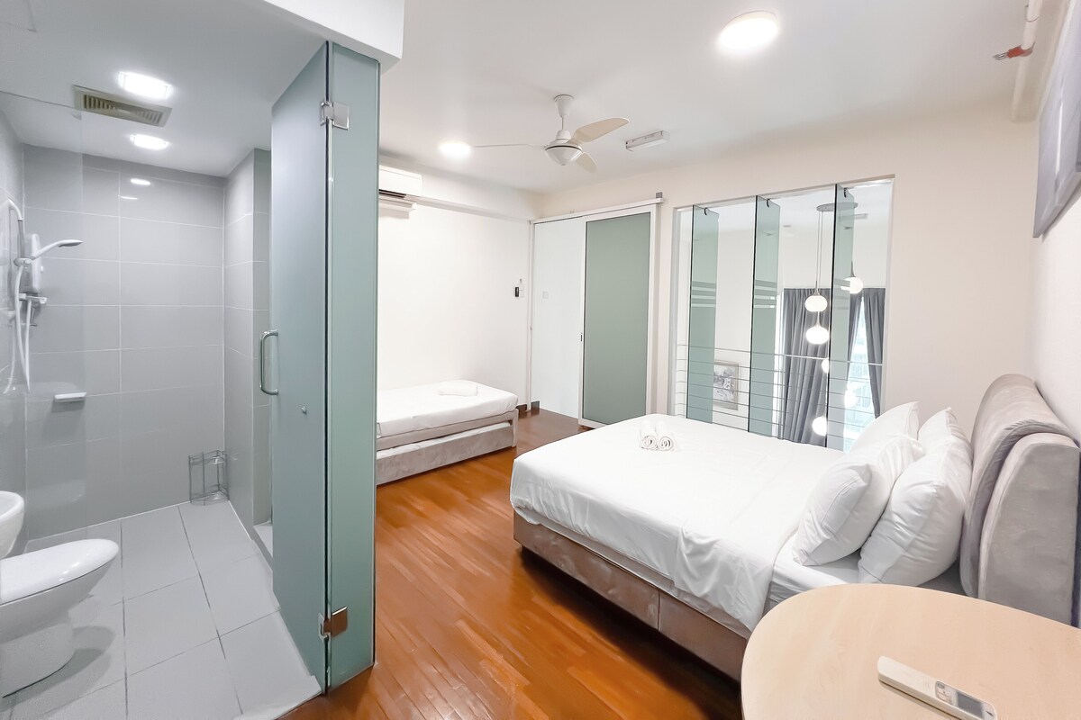Une chambre à coucher moderne avec un lit, une table de chevet, un miroir et un espace douche.