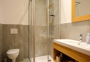 A bathroom with a glass-enclosed shower, a toilet, and a sink with a wooden vanity. - Holiday Home in Tyrol Near Ziller River (Zellberg)