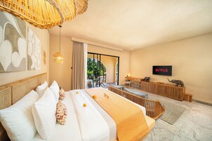 Habitación de hotel con una cama grande, un escritorio, televisión y vistas al exterior.
