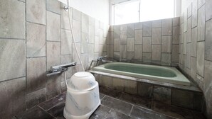 Un baño con bañera, ducha y un pedestal de mármol.