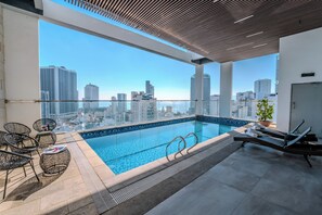 A rooftop infinity pool with city views, lounge chairs, and a potted plant. - Astica Hotel Nha Trang  (Nha Trang)