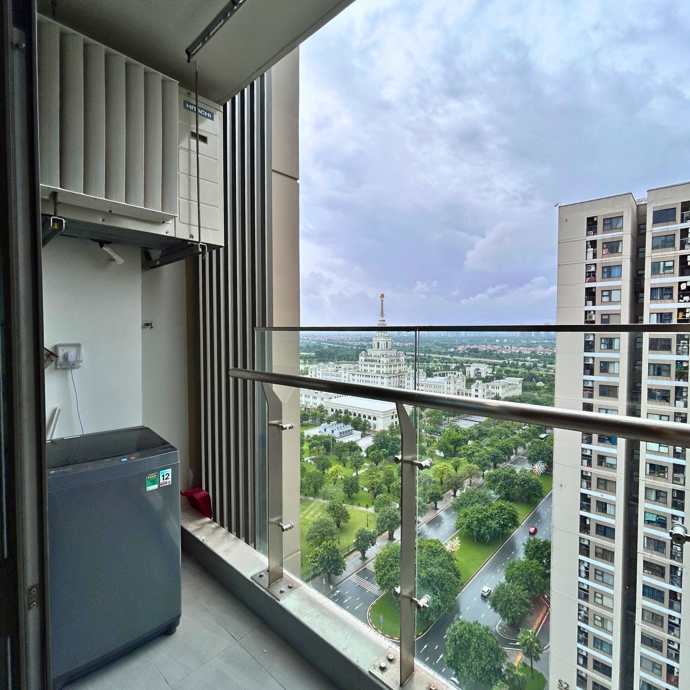 A balcony with a view of a cityscape, including a tall building with a spire.