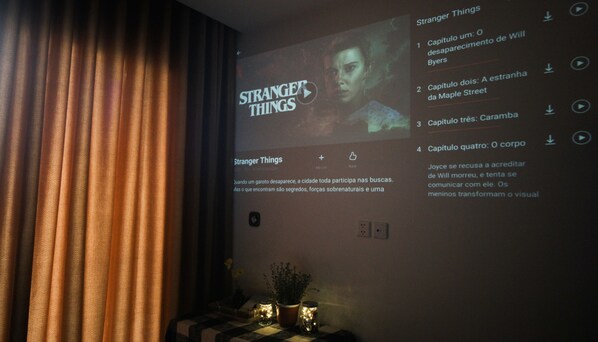 A projection of 'Stranger Things' on a wall with a curtain partially covering the left side. - Vinhomes Ocean Park Apartment Ha Noi - 20 October Homestay (Hanoi)