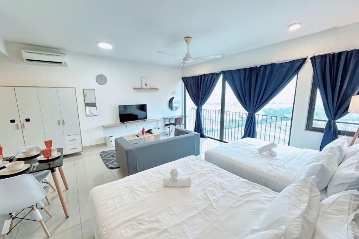 A hotel room with two beds, a TV, a desk, and a balcony with curtains.