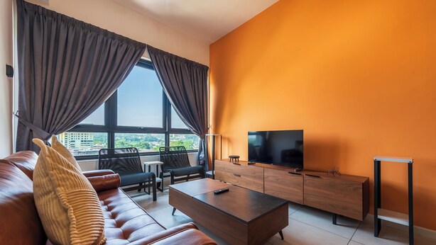 Een moderne woonkamer met een bank, salontafel, televisie en een stadszicht door grote ramen.