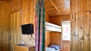 A wooden cabin room with a bunk bed, a desk with drawers, and a television. - 4 Person Holiday Park Home in Kinsarvik (Ullensvang)