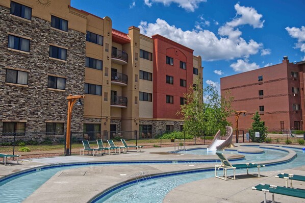 A hotel with a pool area, including lounge chairs and a water slide. - Chula Vista Resort Condo (Wisconsin Dells)