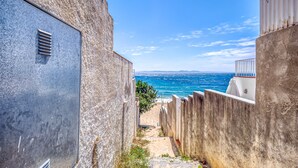A narrow alleyway with a view of the sea. - Beachfront Apartment in Platja Almadrava (Roses)