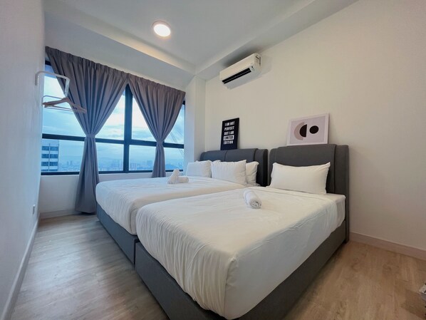 Habitación de hotel con una cama grande, una ventana con cortinas, un aire acondicionado y vistas a la ciudad.