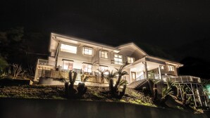 A modern two-story house with a balcony, a covered patio, and a well-lit exterior. - VACATION VILLA BLUE LAGOON (Numazu)