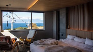 A modern bedroom with a large window offering a view of the sea and mountains. - VACATION VILLA BLUE LAGOON (Numazu)