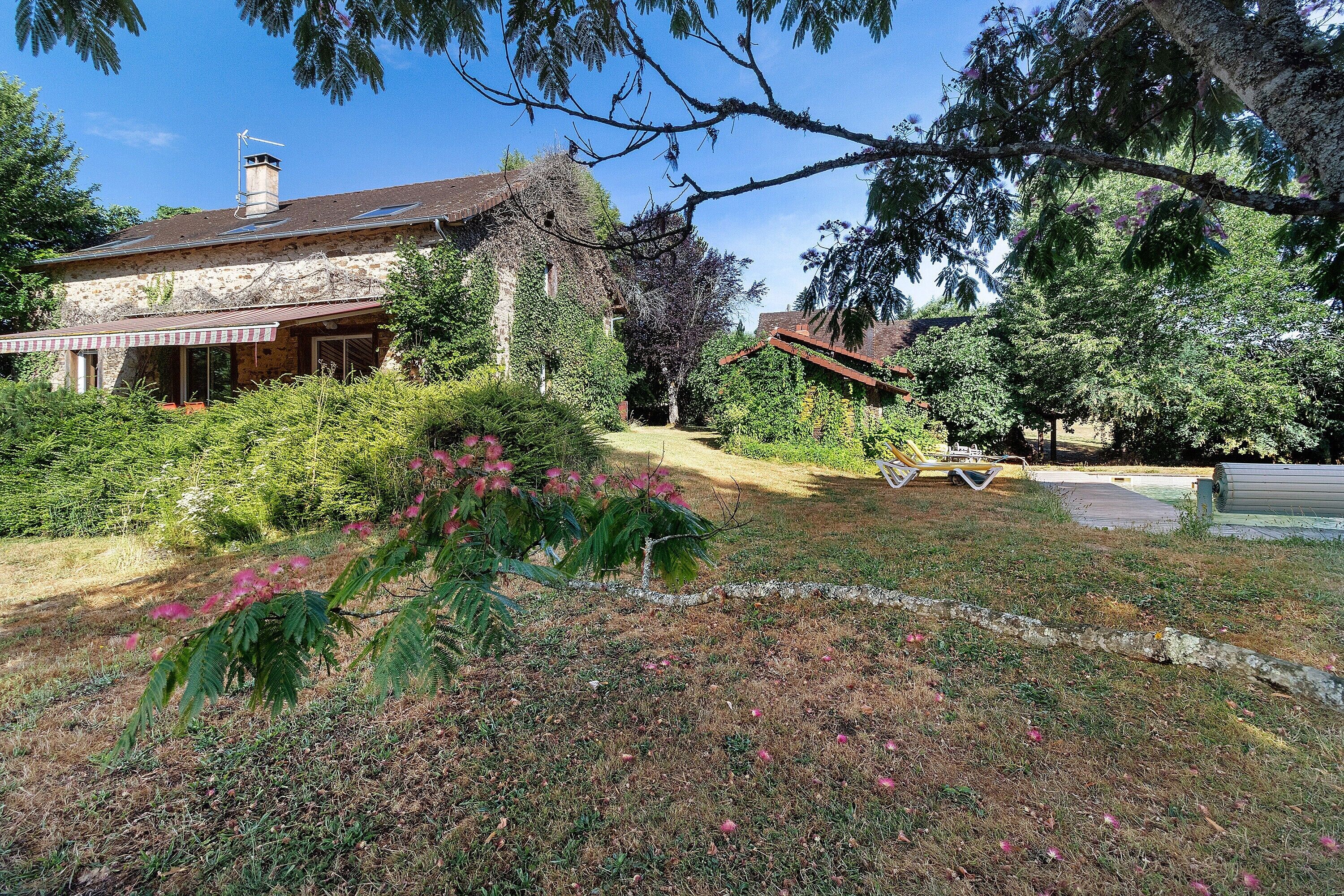 Une maison avec un toit en pente, une cheminée et une véranda couverte.