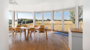 A dining area with a table and chairs, large windows, and a view of the outdoors. - Modern holiday home with private pool and spa in the Périgord countryside (Angoisse)