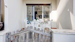 A white interior with a wooden staircase leading to a balcony.